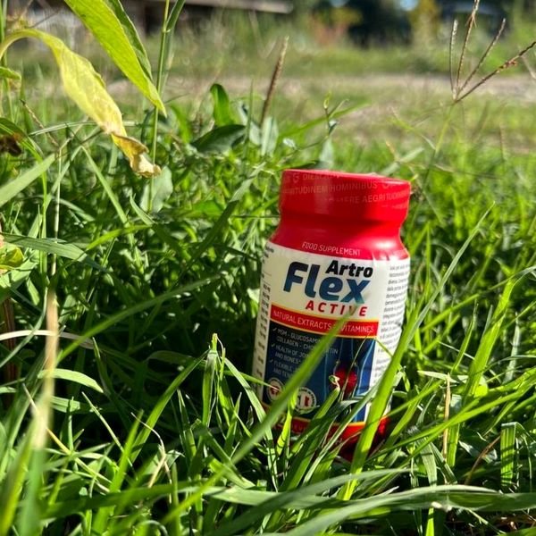 Flacone di Artroflex Active con tappo rosso appoggiato sull'erba