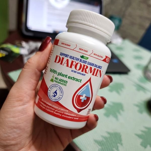Barattolo bianco e rosso di Diaformin da 20 capsule tenuto in mano