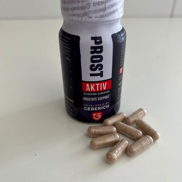 Barattolo scuro di ProstAktiv con le capsule beige accanto
